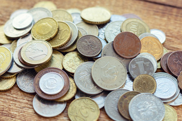 coins old rusty brass euro Seychelles Bulgaria China Germany pile pack heap stack on a wooden background finance economy investment savings concept mock up selective focus close up