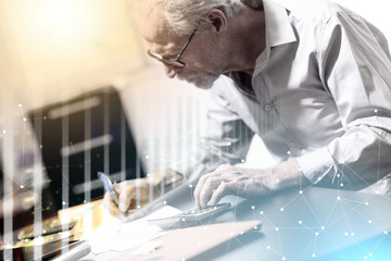 Senior businessman working on business report; multiple exposure