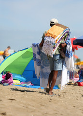 abusive itinerant seller on the sand while selling towels and be