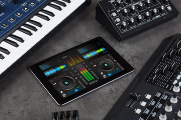 Mixing music on tablet with electronic music instruments concept
