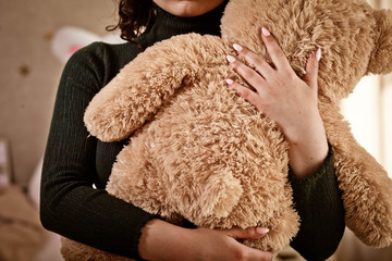 Girl holds a one teddy bear , teddy