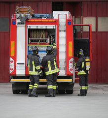 three firemen in action and the fire engine