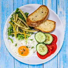 Breakfast - fried egg, toasts and vegetable salad