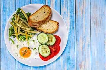 Breakfast - fried egg, toasts and vegetable salad