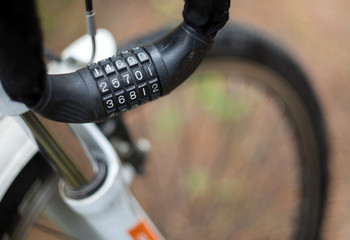 Cable for attaching a bicycle with a combination lock hanging on the handlebars with a blurred...