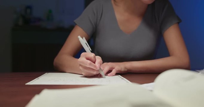 Woman write on the paper at home in the evening - Powered by Adobe