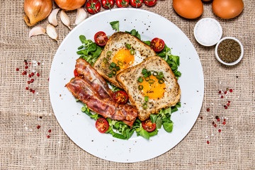 Breakfast - toasted bread with fried egg, bacon and vegetables