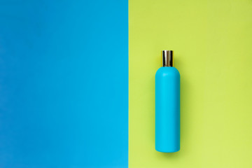 blue bottle on a yellow-blue background. empty space under the text. clean plastic packaging.