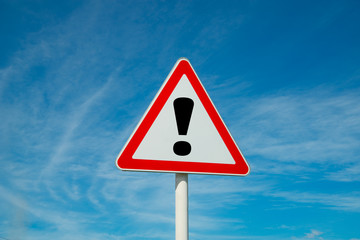 Exclamation point of attention against the sky. triangular sign. Danger, warning.