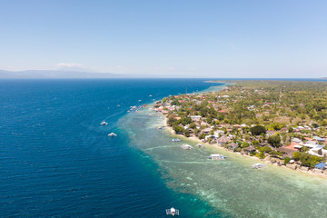 Coast of Cebu island, Moalboal, Philippines, top view. Philippine boats in a blue lagoon over coral reefs. Moalboal is a great place for diving and vacations.