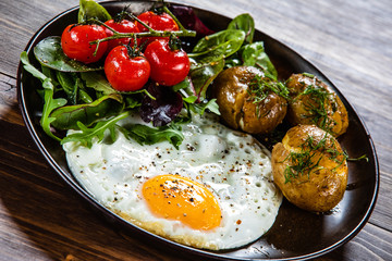 Fried egg, boiled potatoes and vegetables