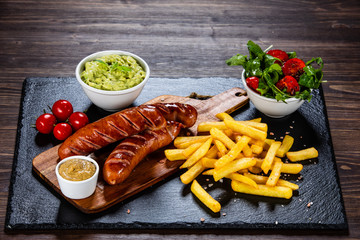 Grilled sausages, French fries and vegetables