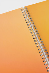 Close up of open notebook with blank orange color pages.