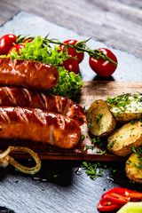 Grilled sausages and vegetables on cutting board