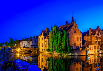 Obraz premium Klasyczny widok na historyczne centrum Brugii (Brugge), prowincja Flandria Zachodnia, Belgia. Nocna panorama Brugii. Kanały Brugii