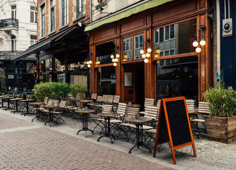 Fototapeta Old street with tables of cafe in historic city center of Antwerpen (Antwerp), Belgium. Cozy cityscape of Antwerp. Architecture and landmark of Antwerpen obraz