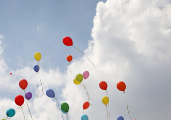 colored balloons fly high in the sky