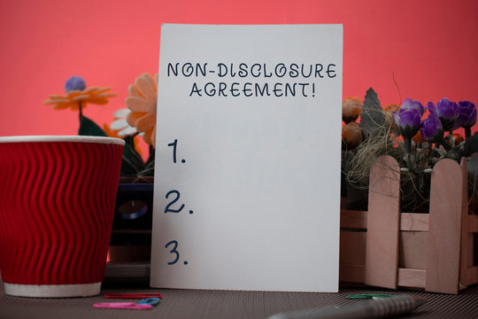 Handwriting text writing Non Disclosure Agreement. Conceptual photo Legal Contract Confidential Material or Information Flowers and stationary plus plain sheet with paper big cup above a table