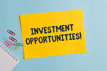 Text sign showing Investment Opportunities. Business photo showcasing a Purchase that has a chance to Gain Value Plain cardboard and writing equipment placed above pastel colour backdrop
