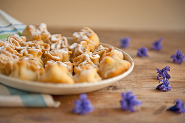 Homemade biscuit with violet hyacinth, white flower and yellow taraxacum on the wooden table