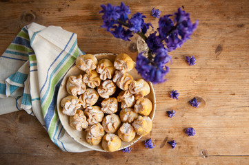 Homemade biscuit with violet hyacinth, white flower and yellow taraxacum on the wooden table