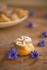 Homemade biscuit with violet hyacinth, white flower and yellow taraxacum on the wooden table