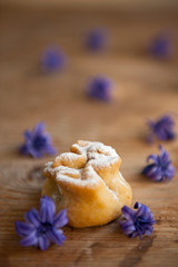 Homemade biscuit with violet hyacinth, white flower and yellow taraxacum on the wooden table