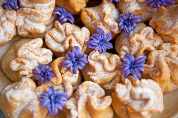 Homemade biscuit with violet hyacinth, white flower and yellow taraxacum on the wooden table