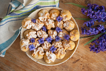 Homemade biscuit with violet hyacinth, white flower and yellow taraxacum on the wooden table