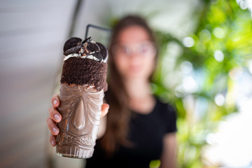 Beautiful women blurred holding a chocolate shake and cookies on a transparent glass with aboriginal design