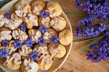 Homemade biscuit with violet hyacinth, white flower and yellow taraxacum on the wooden table