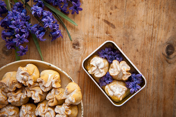 Homemade biscuit with violet hyacinth, white flower and yellow taraxacum on the wooden table