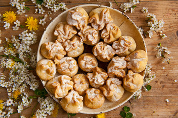 Homemade biscuit with violet hyacinth, white flower and yellow taraxacum on the wooden table