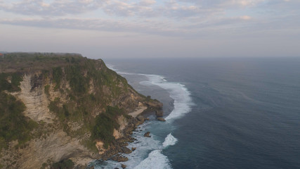Fototapeta na wymiar aerial view rocky ocean coastline at sunset. seascape waves break on rocky shore travel concept.