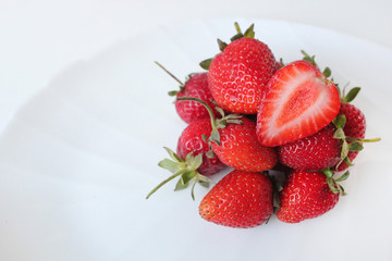 Close-up shot of fresh strawberries on a white plate. Isolated on white background.