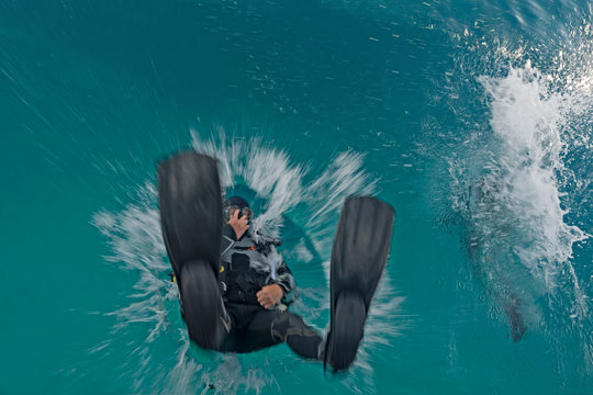 Outdoor photography of a diver enty in to the water.