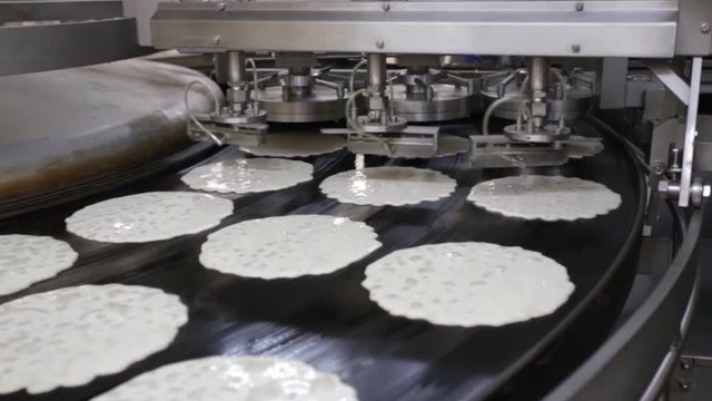 Rawpancakes on hot conveyor belt