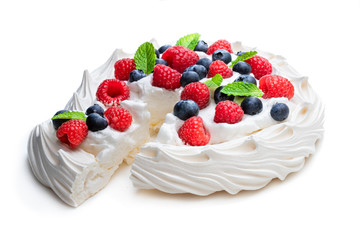 Pavlova meringue nest with berries and mint leaves isolated on white