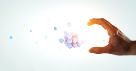 Woman hand and a bunch of spheres levitating above. Mixed media