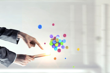 Businesswoman hands holding a smartphone with a bunch of spheres levitating above. Mixed media