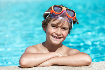 young child smiling in the pool with float and glasses