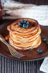 Pancakes with blueberry and honey. On a wooden table with a white towel