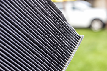 Genutztes Pollenfilter, im hintergrund steht ein Auto