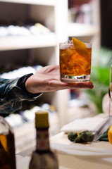 barman holds a glass with a cocktail in hand