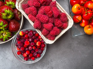 Berries on concrete Background. Summer or Spring Organic Berry. Strawberries, Raspberries, Cherry, Cranberries. Agriculture, Gardening, Harvest Concept