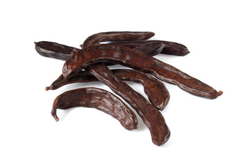  Carob pods on the white background, close-up.