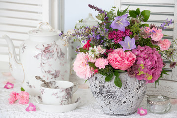 vintage Dekoration mit Blumenstrauß in Pink und antikem Porzellan