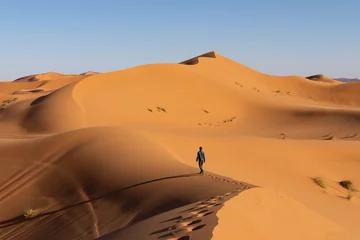 Deurstickers Toerist die in de duinen, Merzouga-woestijn loopt © Suzanne Plumette