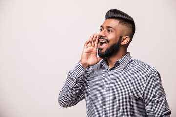 An angry indian man pulling his hair and screaming, isolated on a white background.