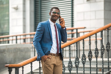 handsome young african man in a suit talking on the phone